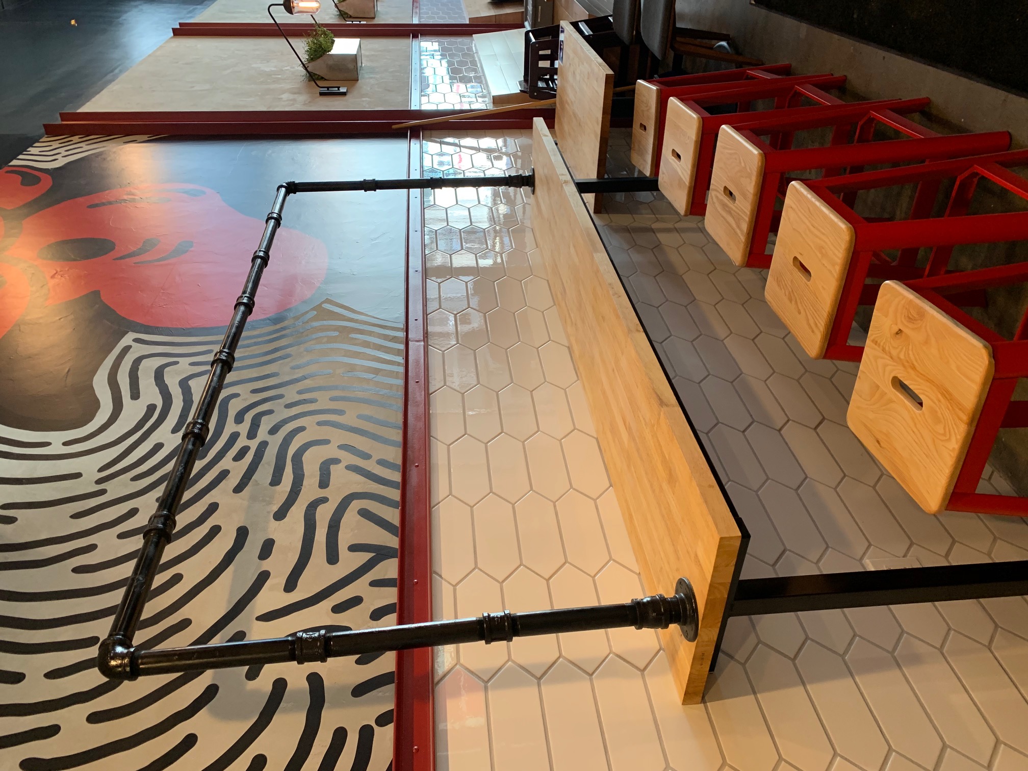 Counter detail with wall mural and industrial pipe railing
