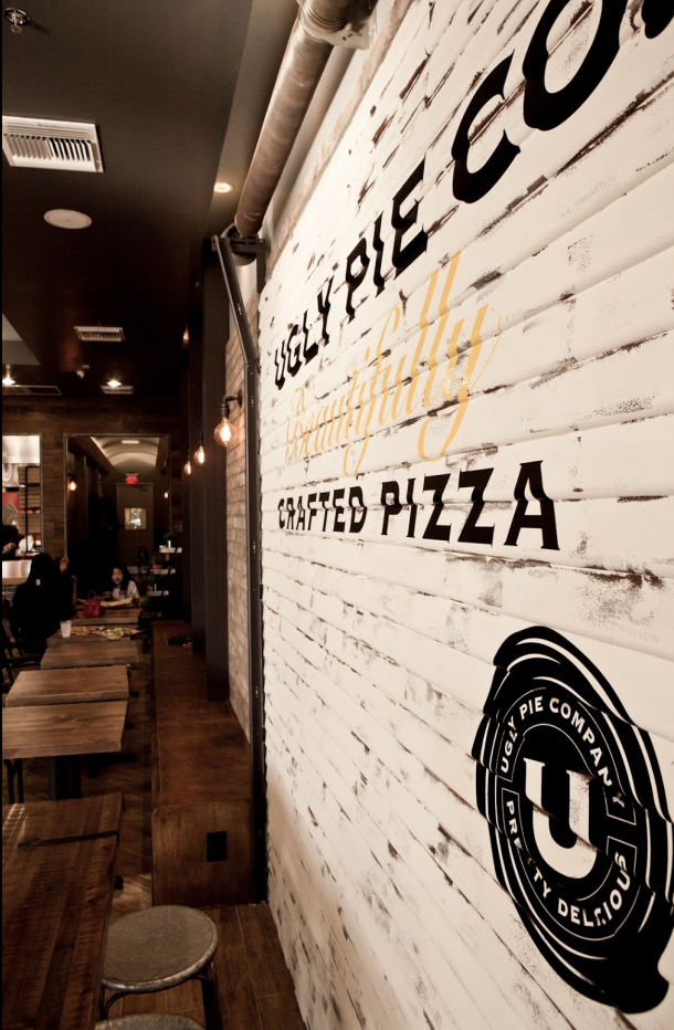 Restaurant entrance — branded brick wall and open sign